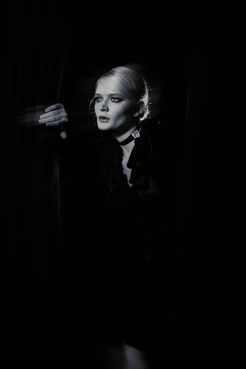 Black and white backstage portrait behind the curtain