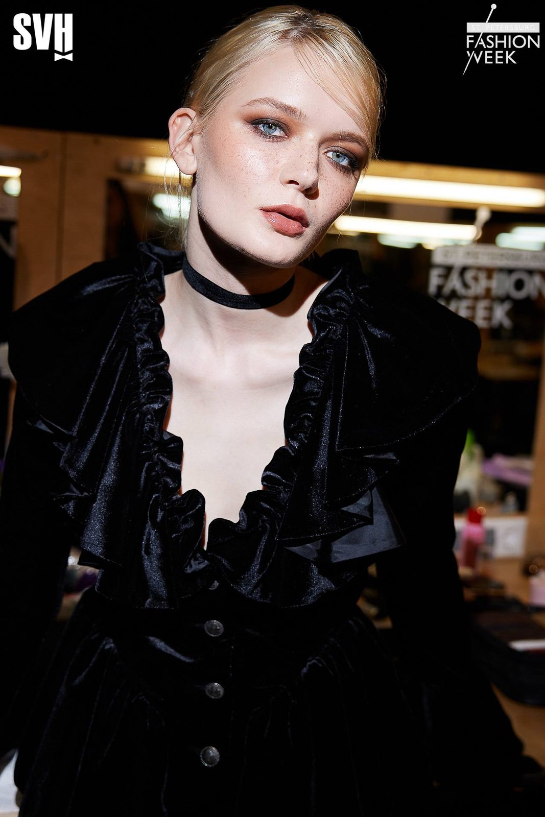 Backstage close-up: freckles, soft smoky eyes, glossy nude lips, black velvet