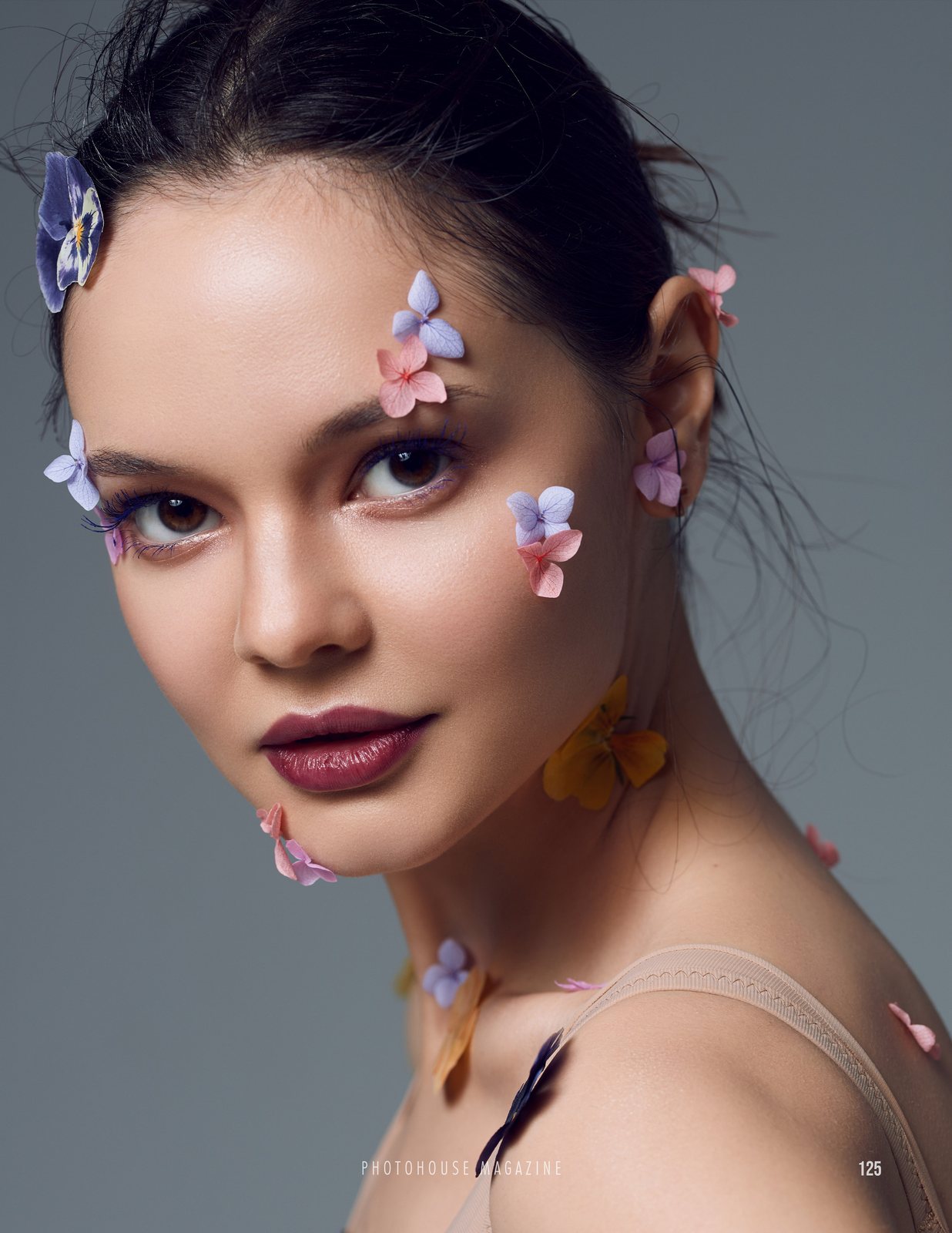Beauty portrait with petals on the skin