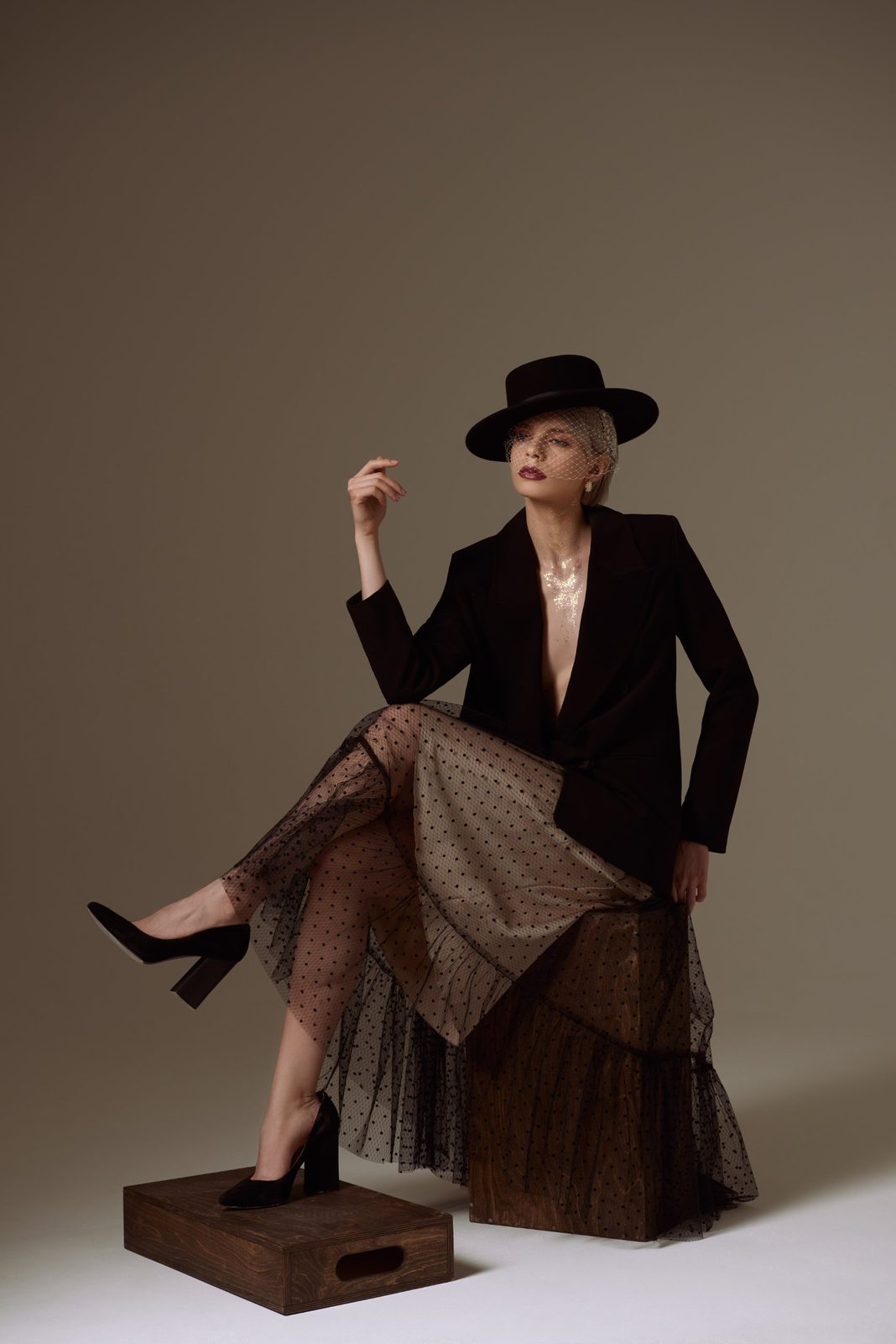 Seated full-length look: hat, veil, polka-dot tulle skirt
